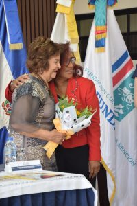 Nurys Veras le obsequia un arreglo de flores a Veronica Sencion.
