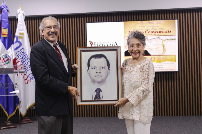 José G. Guerrero Sánchez, director del Museo Nacional de Historia y Geografía, hace entrega a Eulalia Flores del reconocimiento póstumo a Pedro Julio Santiago Canario, exdirector de la institución museística.