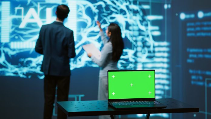 Teamworking AI technicians using green screen laptop for business Cómo evitar que la IA reemplace al periodista