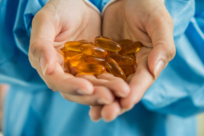 Woman's hand pours the medicine pills out of the bottle Vitamina D muestra potencial para modular la respuesta inmunitaria en la enfermedad inflamatoria intestinal