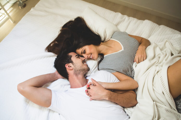 couple-lying-bed-holding-hands-looking-into-each-other-s-eyes La sequedad vaginal no siempre significa falta de deseo sexual